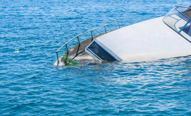 Partially submerged boat after an accident on open water, illustrating the risks and legal complexities of boating incidents.”