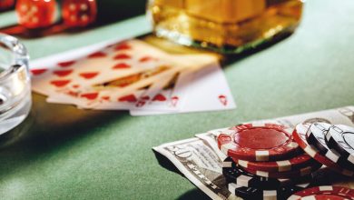 Cards, chips, and a drink on a casino table.