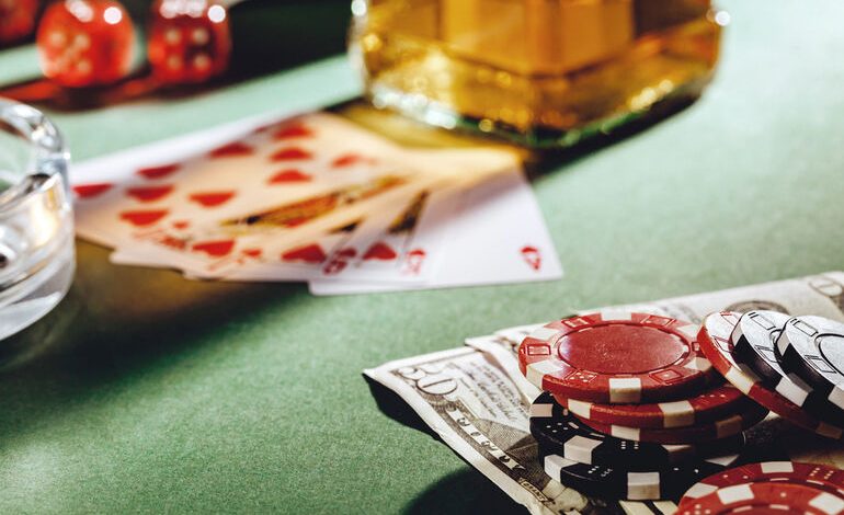 Cards, chips, and a drink on a casino table.