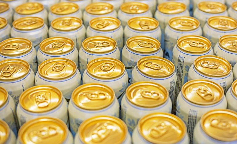 Rows of craft beer cans with gold pull tabs and branding.