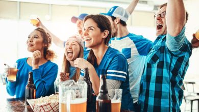 A group of beer-loving friends cheering and raising drinks while celebrating a big win.