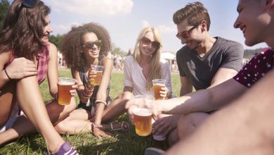 Group of friends sitting on the grass at an outdoor festival in San Diego.