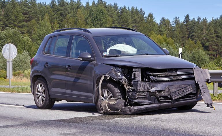 Damaged SUV after front-end collision on a rural road, deployed airbags visible, highlighting car accident impact and vehicle safety risk.