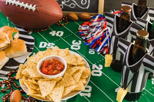 Bottles of beer with snacks on a table, game day setup for watching NFL Sundays at a craft beer bar in San Diego.