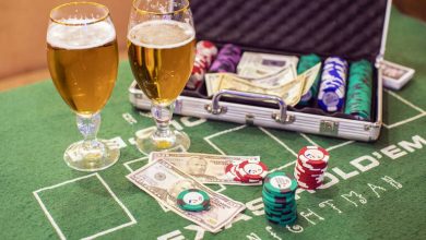 Beer glasses beside casino chips and cash on the table.