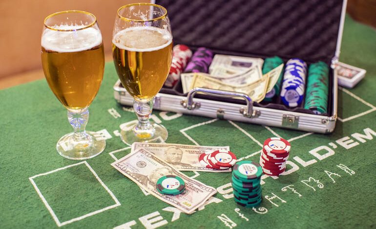 Beer glasses beside casino chips and cash on the table.