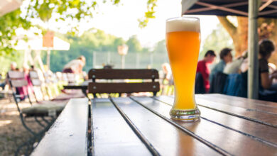 A glass of golden tank beer on a wooden table at an outdoor brewery, representing Brno’s hidden breweries and outstanding tank beer.