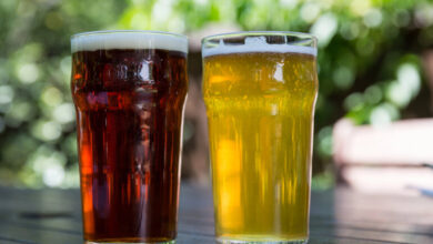 Two pint glasses on a wooden table.