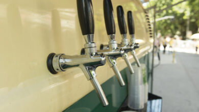 Mobile beer taps on the side of a vintage van.