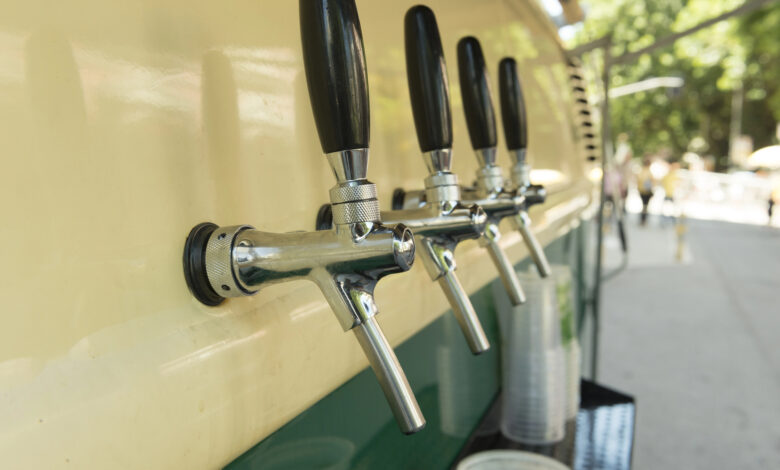 Mobile beer taps on the side of a vintage van.