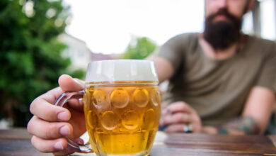 A man carrying a mug of beer, which shows how beer affects a man's testosterone.