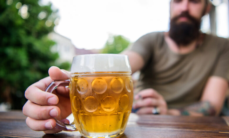 A man carrying a mug of beer, which shows how beer affects a man's testosterone.